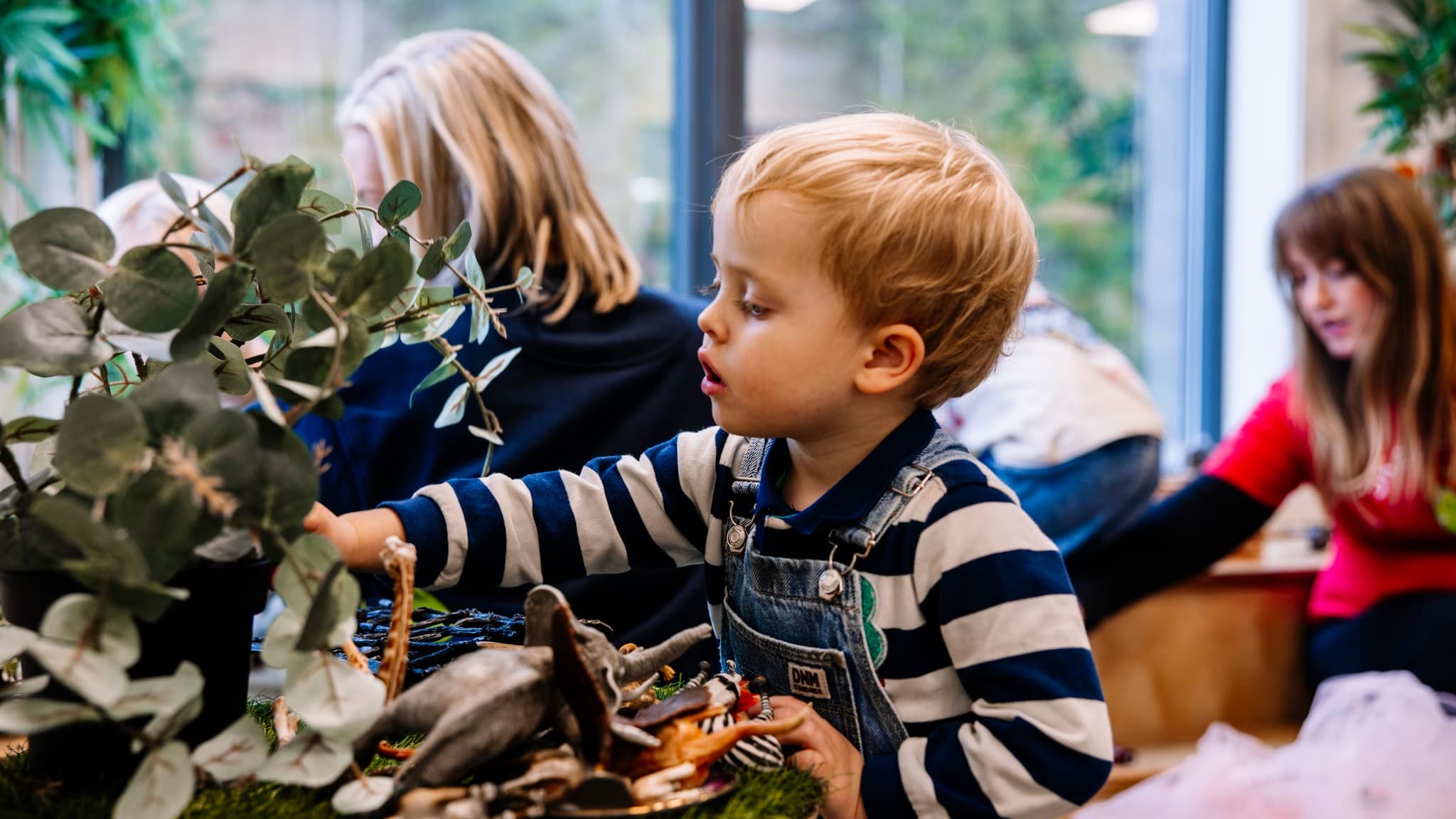 Liten gutt som leker med dyr og planeter i Espira