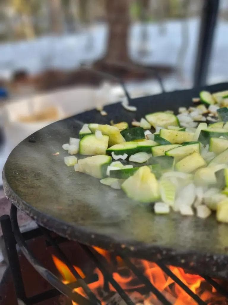 vegetables are being cooked on a pan over a fire .