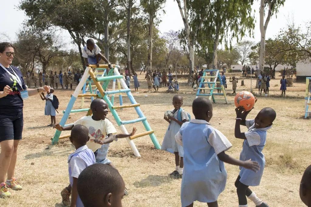 a group of children are playing with a ball in a playground .