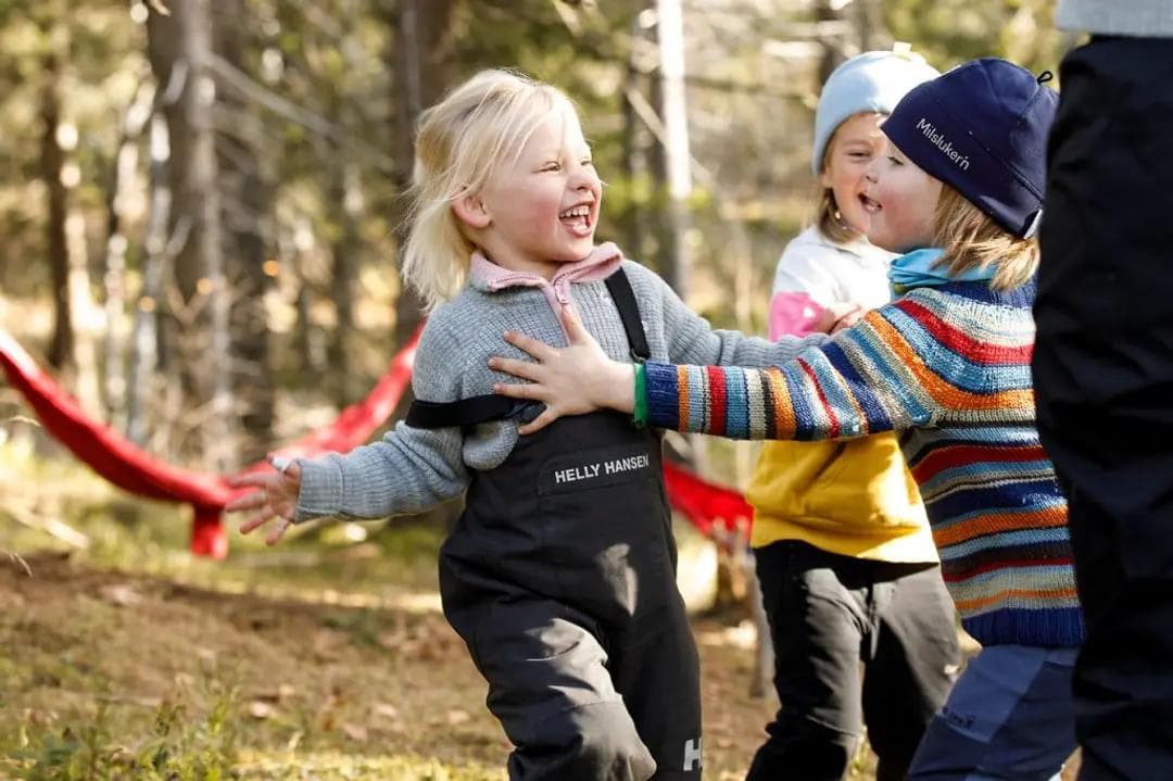 a group of children are playing in the woods .